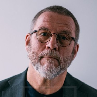 Porträttbild på en man med glasögon och skägg