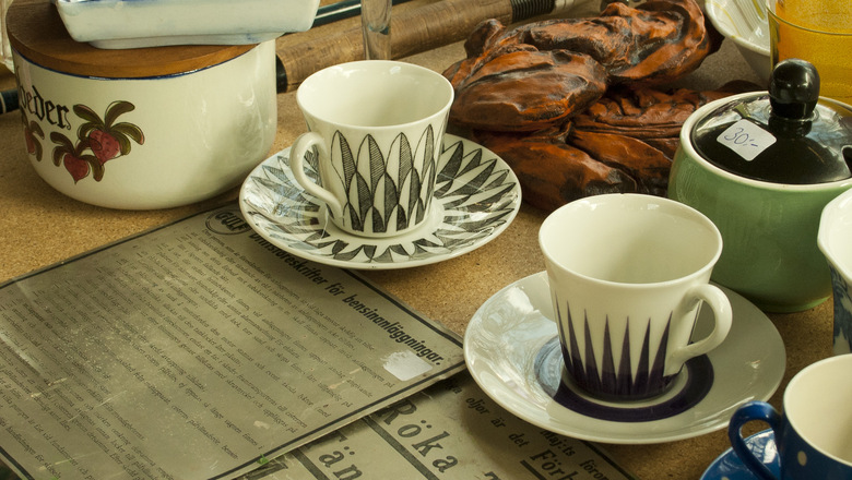 Loppisbord med kaffekoppar och keramikskålar.