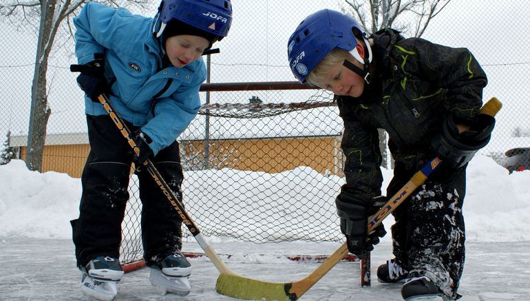 två små killar som spelar hockey