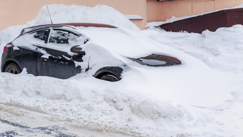Car blocked under Snow after snowstorm in winter. Concept of weather, transport, cleaning streets in winter