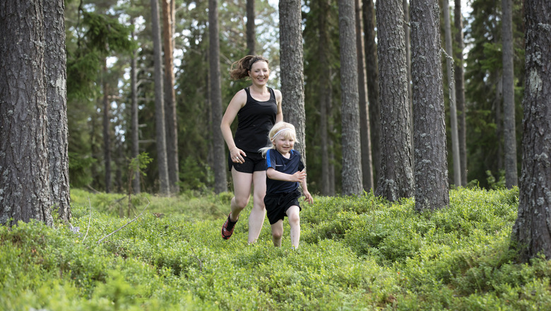 kvinna och barn springer i skogen