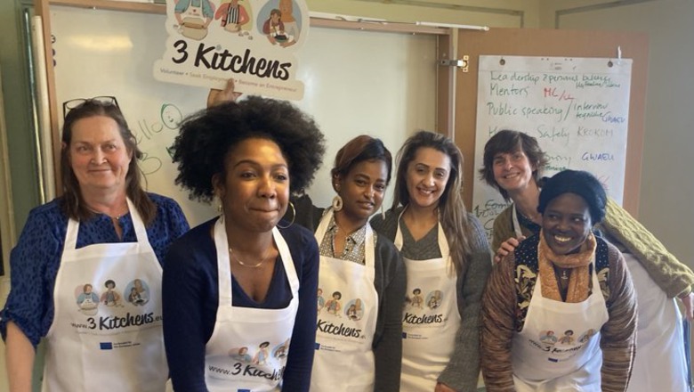 sex kvinnor står på rad och ser glada ut. De har på sig 3 kitchens-förkläden.