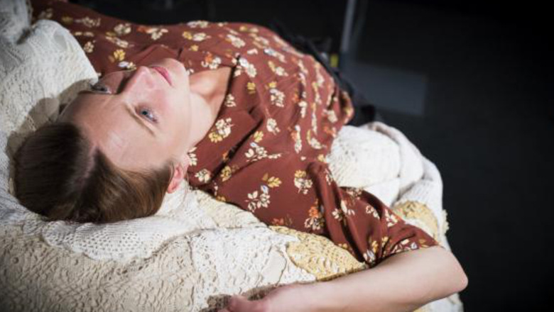 Bild på en kvinna som ligger med huvudet på en kudde och blickar uppåt
