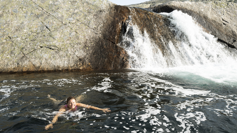 En kvinna badar i en å