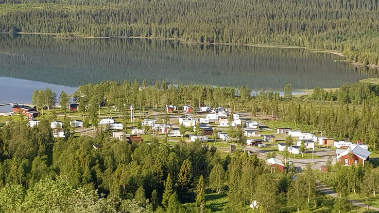 vy över camping intill sjö omgiven av skog 
