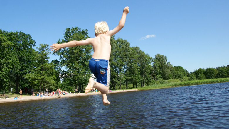 Pojke hoppar i vattnet från en brygga