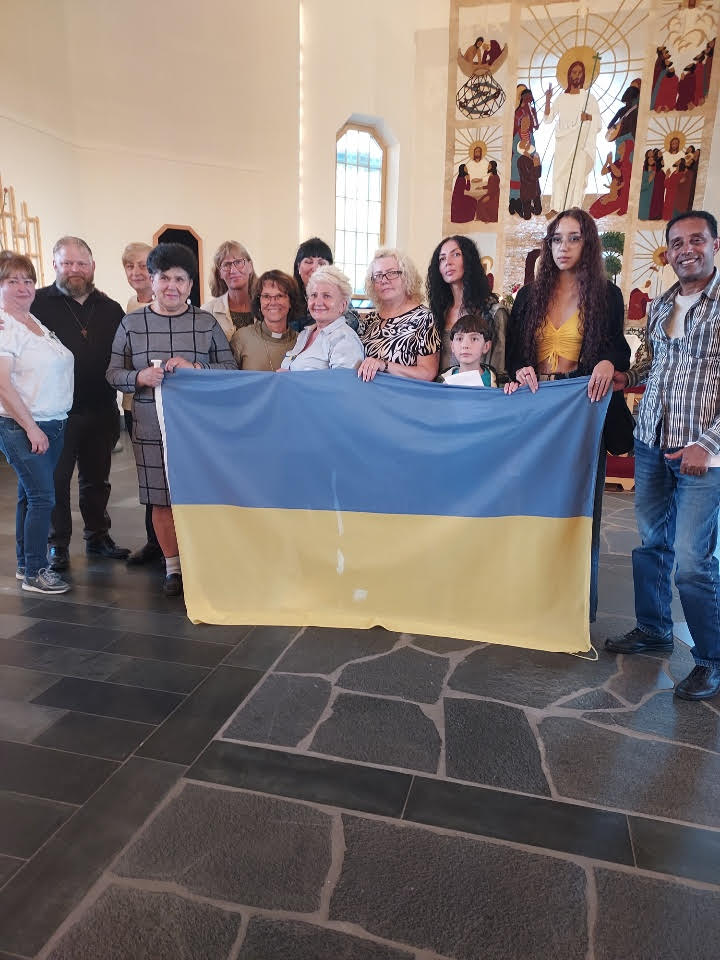 Grupp människor som och håller upp Ukrainas flagga. 