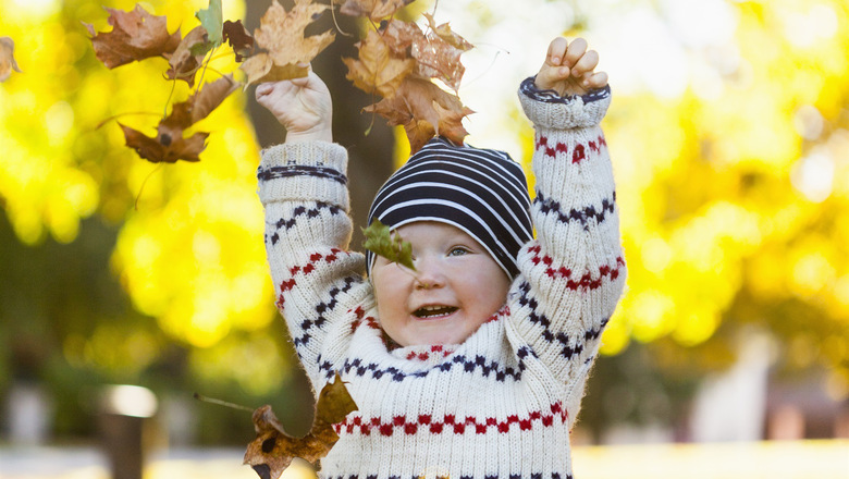 Litet barn som kastar löv i luften